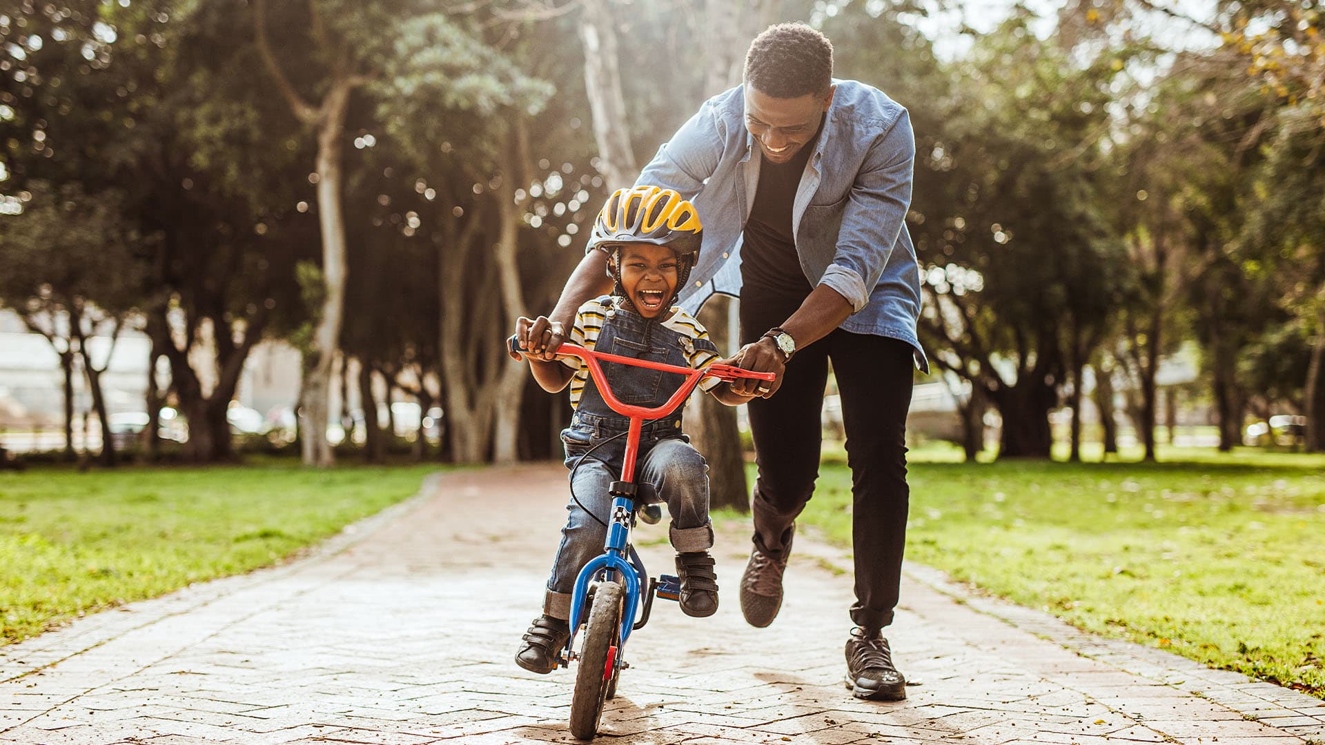 Father teaching his son cycling at park